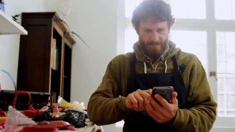 craftsman using mobile phone in workshop 4k