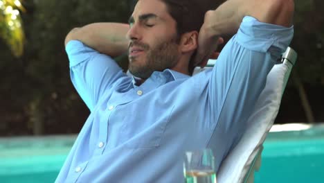 businessman relaxing on deckchair poolside