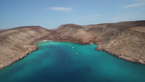 Toma-Aérea-De-Una-Ensenada-Con-Botes-Y-Playitas-En-La-Isla-Partida,-Parque-Nacional-Archipiélago-Espíritu-Santo,-Baja-California-Sur