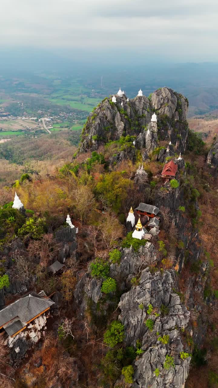 aerial drone sky temple in Lampang Thailand mountaintop pagodas of Wat Chaloem Phra Kiat vertical