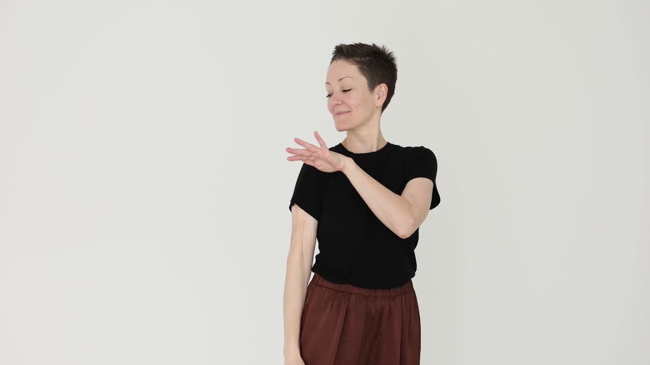 Expressive woman with short hair making hand gestures on white background