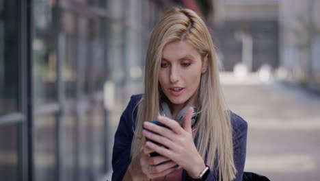 Retrato-Joven-Y-Atractiva-Mujer-De-Negocios-Rubia-Usando-Un-Teléfono-Inteligente-Tomando-Una-Foto-Selfie-En-La-Ciudad-Disfrutando-Posando-Compartiendo-Un-Estilo-De-Vida-Urbano-Relajado-En-Cámara-Lenta