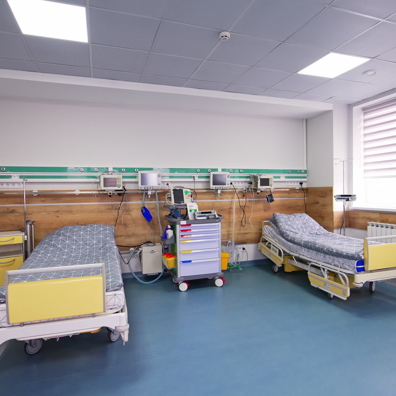 Entering light and spacious room with beds and equipment for reanimation. Intensive care unit ward with no patients