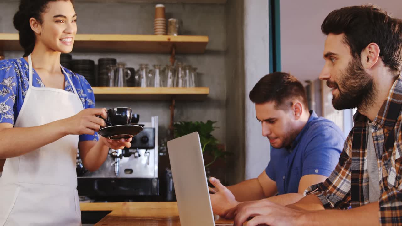Amici che usano il laptop mentre bevono un caffè