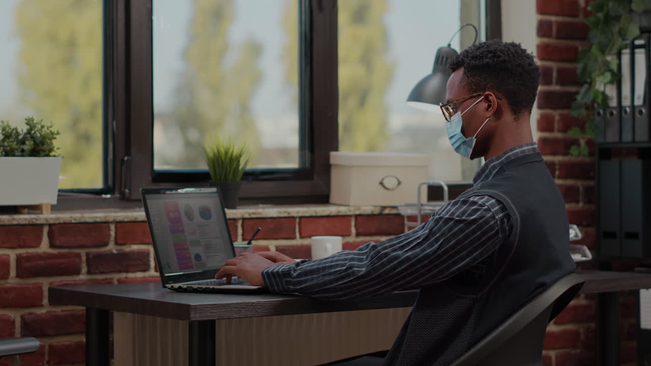 African american worker analyzing commercial growth on laptop