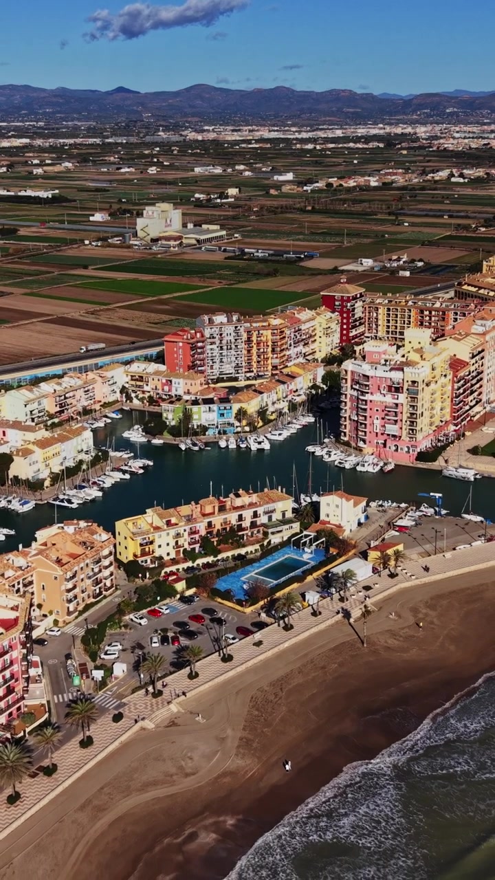 Kystudsigt over Spanien med vand, bygninger og landbrugsjord i baggrunden