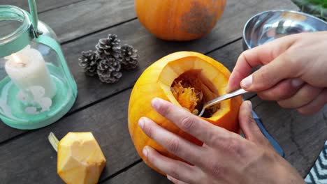 Close-up-of-male-hands-hollowing-out-pumpkin-for-Halloween-Jack-o-lantern