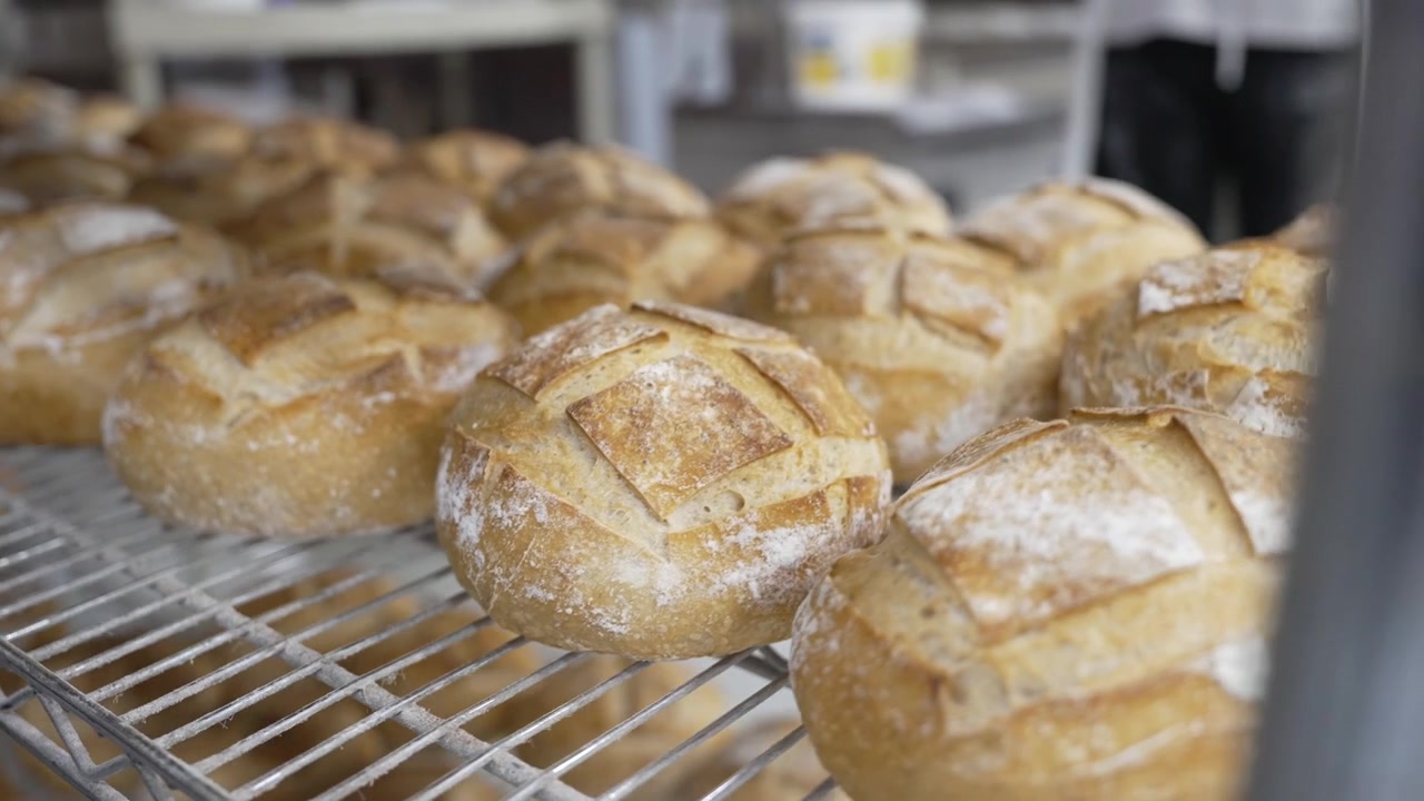 A woman preparing dough in a private bakery, captured in 4K resolution at 60fps, slow motion.