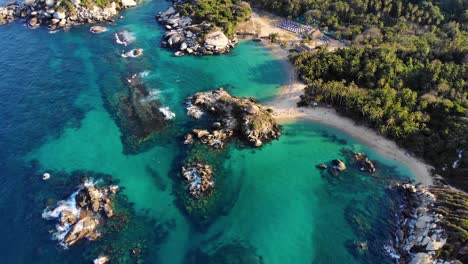 Vista-Aérea-Con-Vistas-Al-Mar-Azul,-Las-Playas-Y-La-Paradisíaca-Costa-De-Tayrona,-Colombia---Reversa,-Tiro-Con-Drones