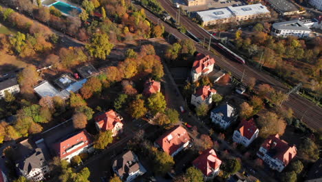 Small-village-next-to-railway-in-Magdeburg-Germany,-slow-aerial-flyover