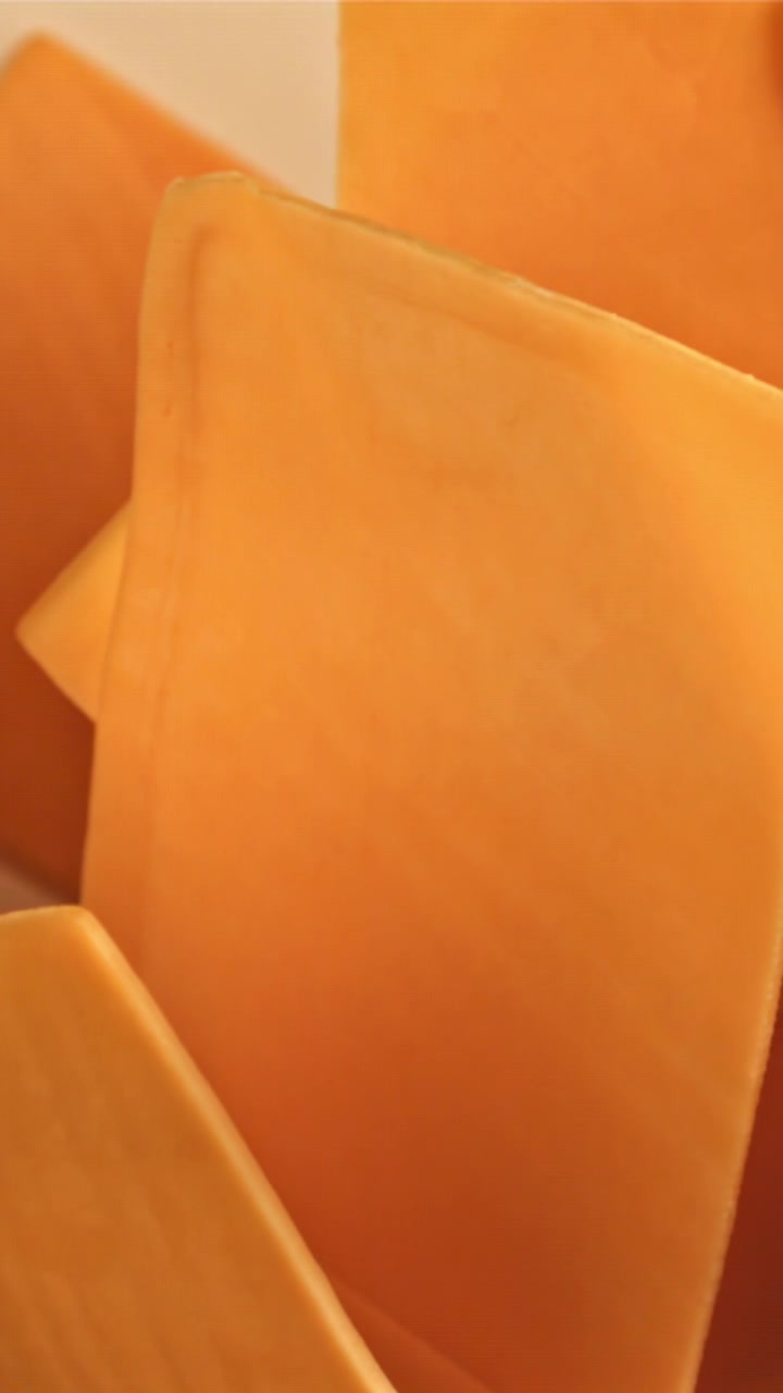 Primo Piano di Fette di Formaggio Giallo Arancione che si Allontanano Lentamente (Zoom Out)