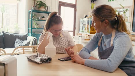 Mädchen-Mit-Down-Syndrom-Surft-Während-Der-Pause-Im-Café-Zusammen-Mit-Ihrer-Arbeitskollegin-Am-Telefon