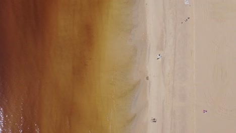 beach aerial top down view with a few people on the shore