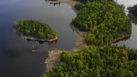 early fall aerial footage of remote lake in northern maine panning down towards island near shore