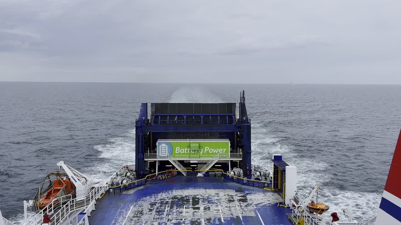 vista del final de un ferry de automóvil navegando a través del mar bajo un cielo nublado, barco azul y blanco