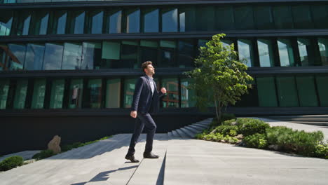 confident man running stairs up urban street rushing to office. boss hurrying