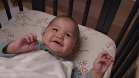 cute baby laughing and smiling in crib