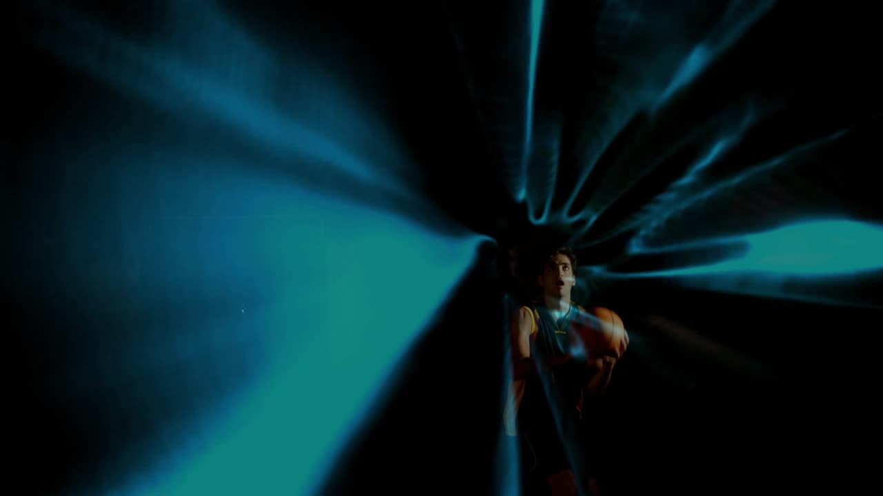 Male basketball player releasing court shot to score creating blue tunnel guiding ball through rim