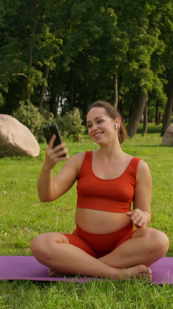 mujer embarazada tomando selfies en el parque