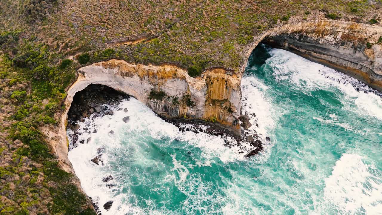 Drone footage captures the dramatic cliffs and turquoise waves of Port Campbell, Australia, highlighting natural erosion and coastal beauty