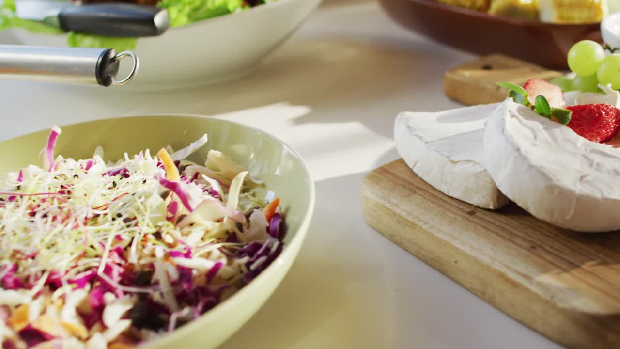 vídeo de una comida saludable y apetitosa con queso, frutas, ensalada, verduras y pollo en la mesa