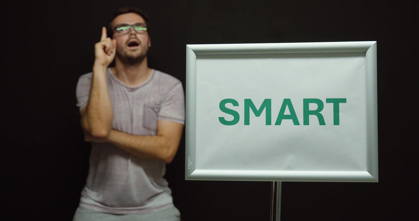 Man adjusting his glasses and thinking next to a smart sign, representing intelligence, knowledge, ideas, problem solving, and smart decisions.