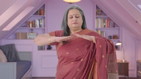 Relaxed-Indian-old-woman-doing-breathe-in-breathe-out-exercise