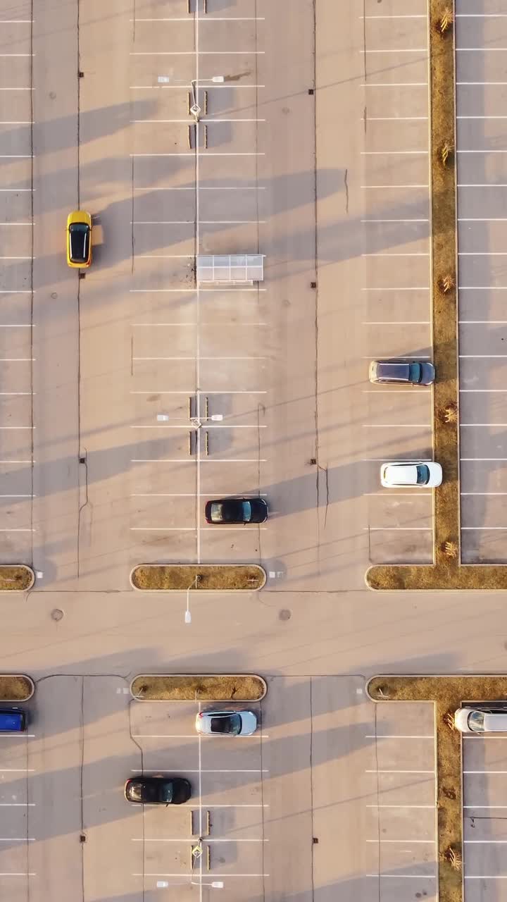 Cars parked in neat rows during sunset in Riga, Latvia, vertical overhead framing, tracking left
