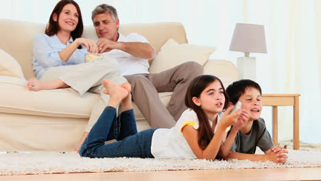 family laughing in front of tv