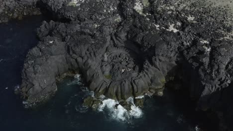 acantilados de basalto oscuro en la costa de islandia durante el día soleado, antena