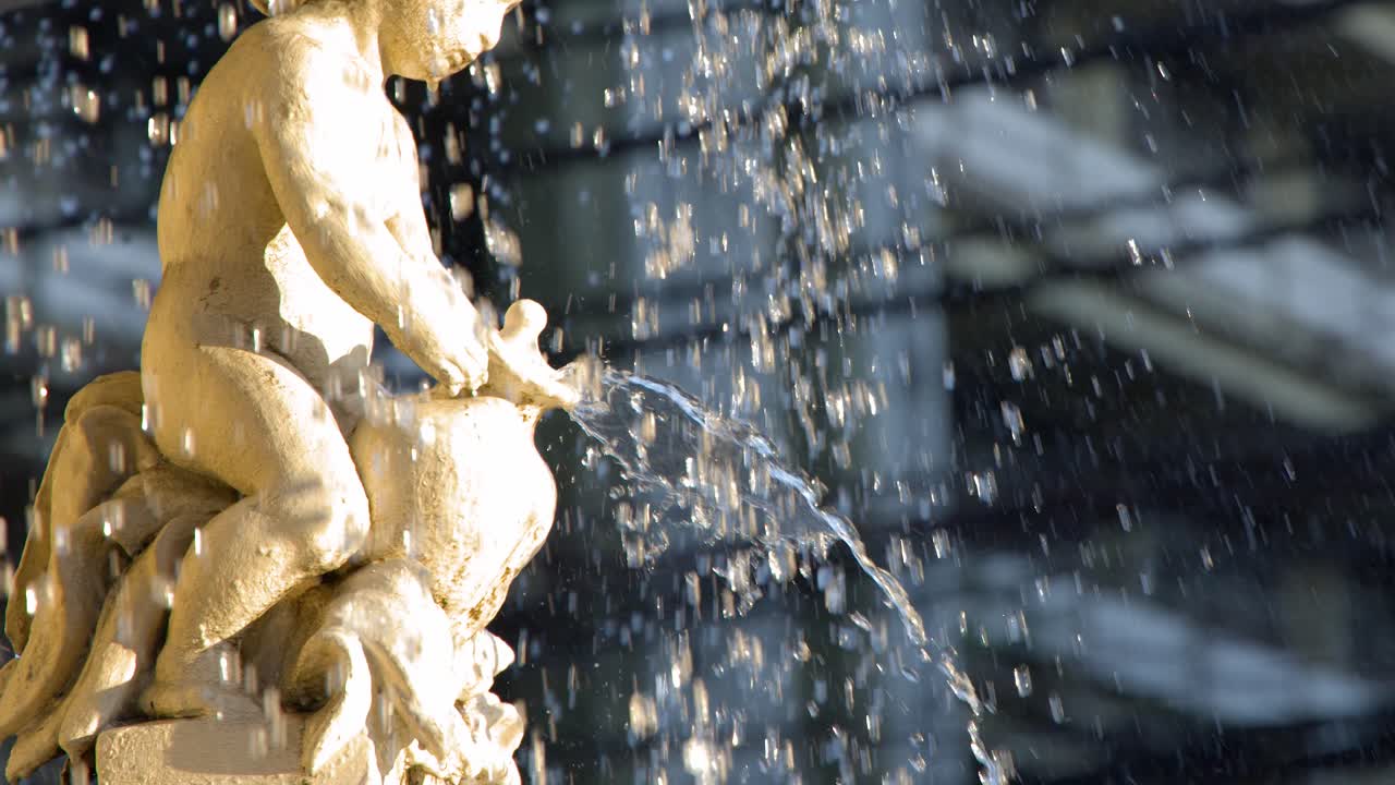Primo piano dell'acqua che zampilla da una statua di cherubino in pietra in pieno giorno