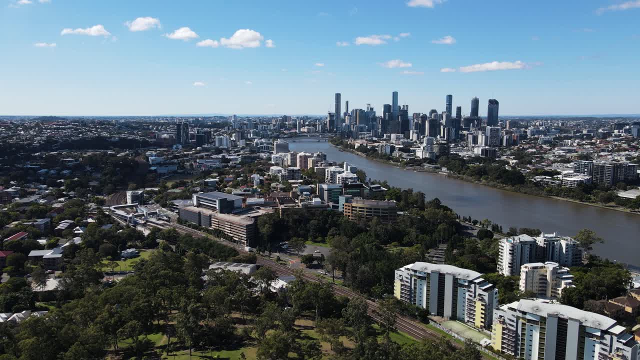 Brisbanes tårnhøje skyline og omkringliggende forstæder bygget langs Brisbane-floden