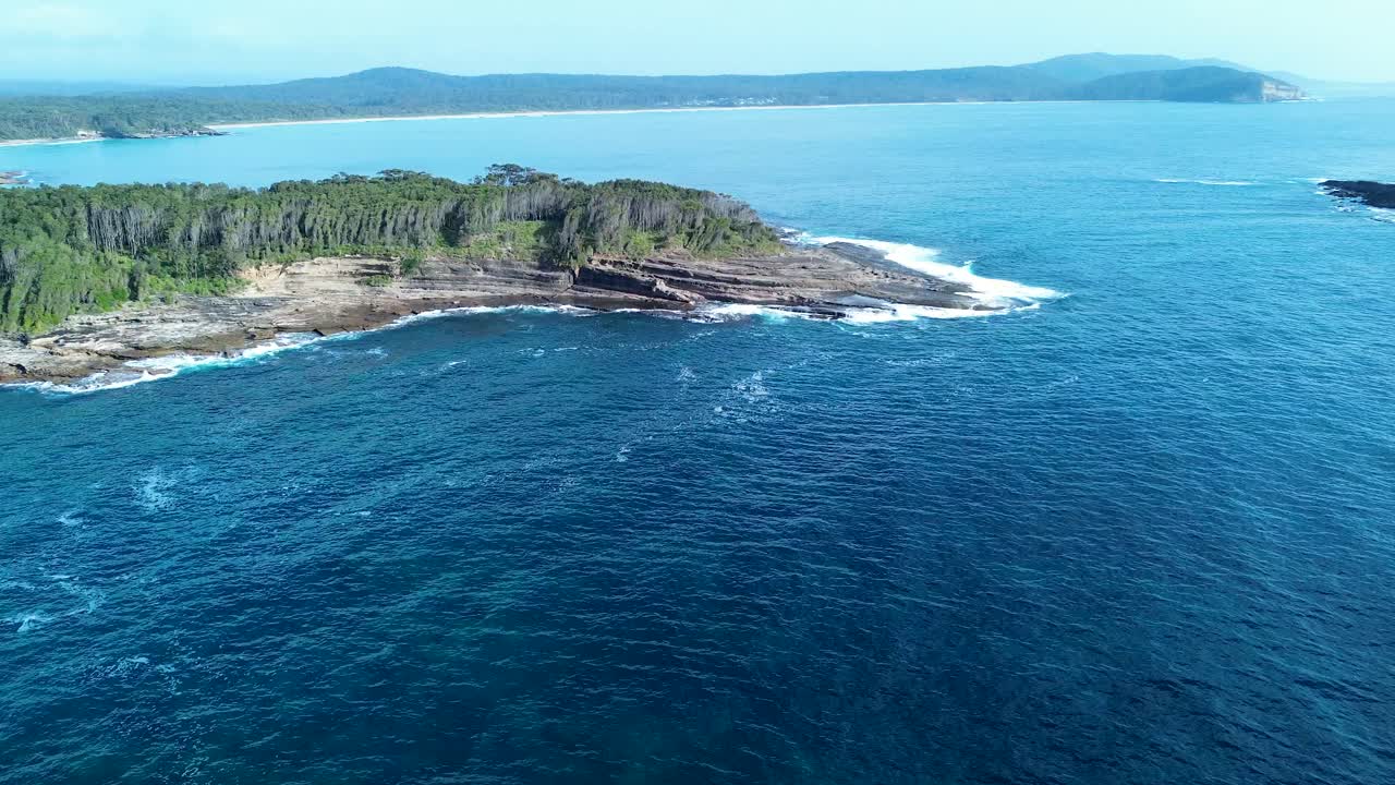 Drone aerial landscape of bushland forest and rocky reef Mill Point Wasp Island headland sea coastline of South Durras Australia wilderness outdoors travel tourism
