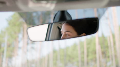 woman adjusting rear mirror