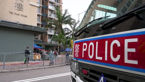 Se-Ve-Una-Furgoneta-De-La-Policía-Estacionada-Fuera-De-Un-Complejo-De-Edificios-Residenciales-Bajo-El-Bloqueo-Del-Coronavirus-Covid-19-Después-De-Que-Un-Gran-Número-De-Residentes-Dieron-Positivo-En-Hong-Kong