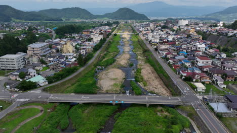 yamanochi town and yomase river, summer in japan - descending tilt drone shot