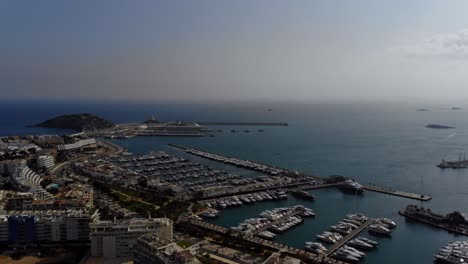 Dron-Panorámico-Por-El-Horizonte,-El-Puerto-Deportivo-Y-La-Ciudad-De-Ibiza