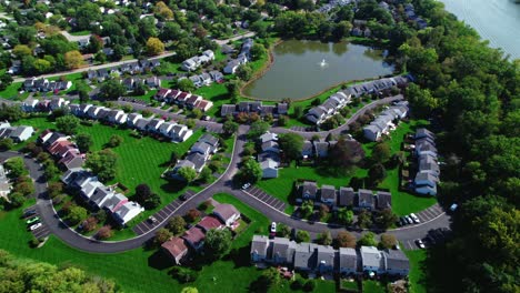 Orbitalblick-über-Ein-Bescheidenes-Vorstadtviertel-Mit-Gras-Und-Einem-See-Mit-Springbrunnen-An-Einem-Sonnigen-Tag,-Crystal-Lake-Illinois