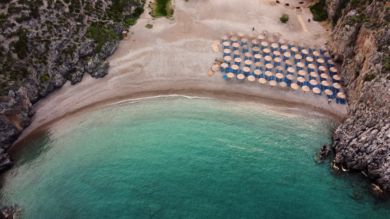 Aerial Drone shot of the crystal clear waters and pebbled beach of Chalkos Beach, Kythira, Greece.