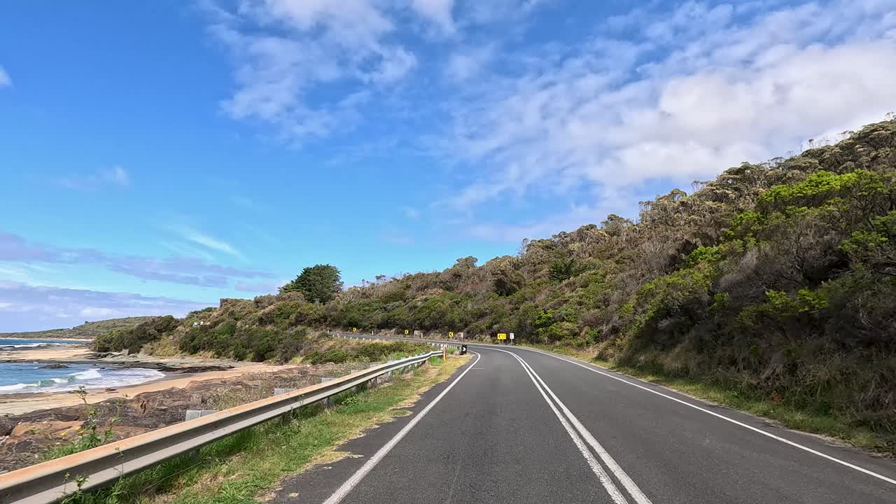 A 30-second journey showcasing the winding coastal road, lush greenery, and ocean views under a bright blue sky