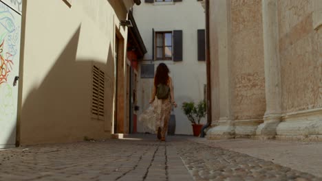 female tourist walks through alley in ancient city center, verona