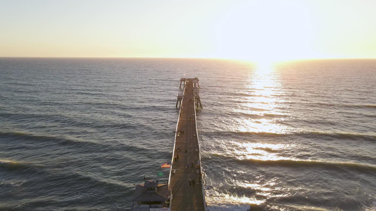 toma aérea de drones volando directamente sobre la parte superior del muelle de san clemente, california, durante la puesta de sol y el cielo despejado