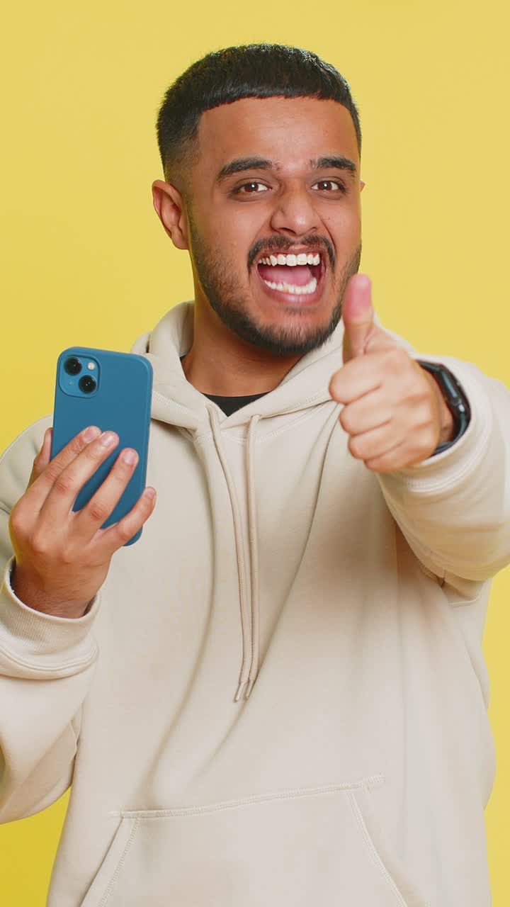 feliz ganador emocionado hombre usar teléfono inteligente celebrar el éxito ganar jugar juego buenas noticias de lotería