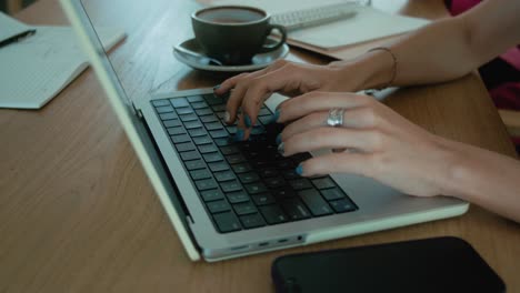 mujer trabajando en una computadora portátil en un café