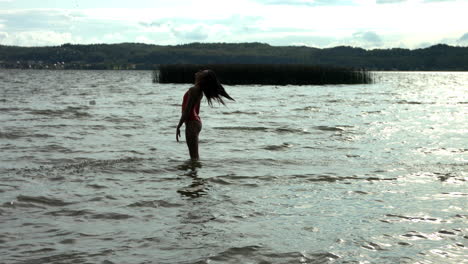 silhouette of woman throwing own hairs into air in ocean,slow motion shot