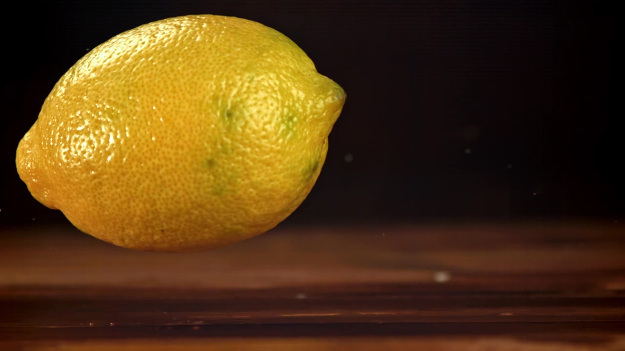 Limone fresco che cade con schizzi d'acqua al rallentatore.