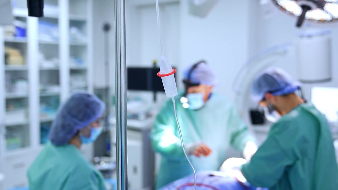 Contagocce sul supporto in sala operatoria. Equipe medica che opera un paziente sullo sfondo sfocato
