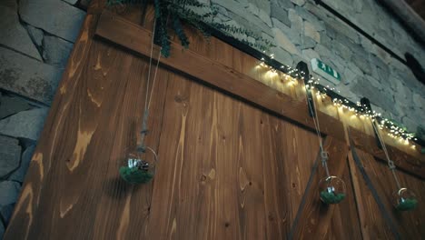 decorative pinecones inside crystal balls hanging from above a wooden door