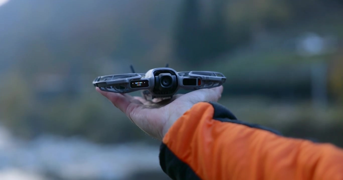 Vista macro di un drone quadricottero compatto DJI Neo che decolla dal palmo della mano di un pilota maschio