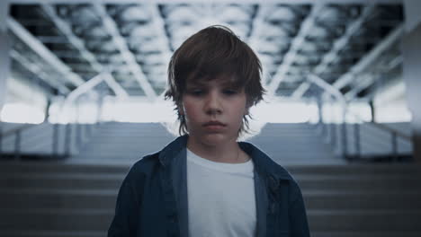 portrait teen boy standing alone full of despair in hall. schoolboy posing alone